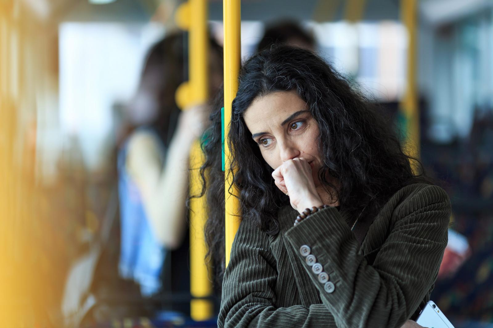 A women looking concerned on a bus