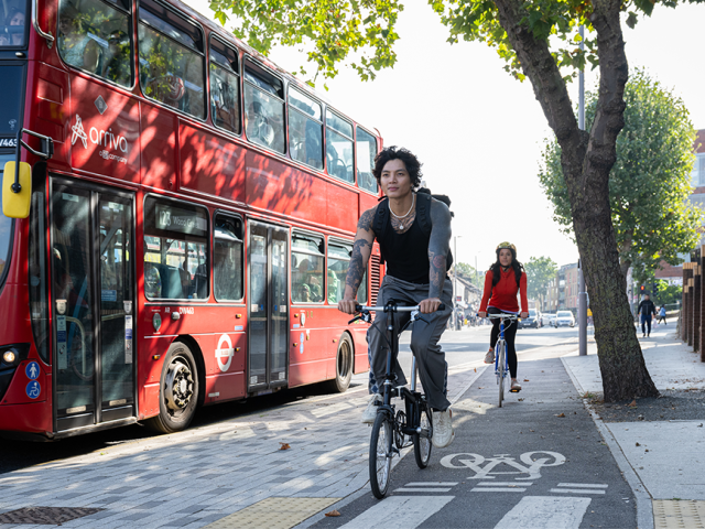 People cycling alongside a bus in London