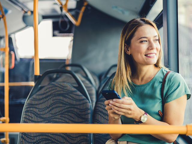 A smiling woman on a bus