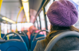 A woman in a purple hat on the bus